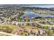 Aerial view of a neighborhood showcasing proximity to a lake and natural surroundings. Located near a lake at 11434 Wishing Well Ln, Clermont, FL 34711