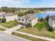 Aerial view of home with a well-manicured lawn and a serene lake in the background at 11434 Wishing Well Ln, Clermont, FL 34711