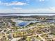 Beautiful aerial view of a community with lush trees, ponds, and homes under a partly cloudy sky at 11434 Wishing Well Ln, Clermont, FL 34711