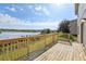 Spacious wooden deck with a railing overlooking a serene lake view at 11434 Wishing Well Ln, Clermont, FL 34711