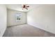 Light-filled bedroom with neutral carpet, ceiling fan and a window at 11434 Wishing Well Ln, Clermont, FL 34711