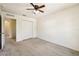 Carpeted bedroom featuring a ceiling fan, closet, and bright neutral paint at 11434 Wishing Well Ln, Clermont, FL 34711