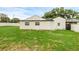 View of the home's backyard, featuring a well-maintained lawn and a partial view of the home's white siding at 1211 Dorothy St, Lakeland, FL 33815
