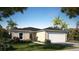 One-story home with attached garage, landscaping, and palm trees at 1270 3Rd W St, Orange City, FL 32763