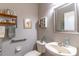 Cozy half bathroom with decorative shelves, a pedestal sink, and neutral gray walls at 12918 Hunters Vista Blvd, Orlando, FL 32837