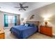Comfortable bedroom featuring a wicker headboard, ceiling fan, and blue accents at 12918 Hunters Vista Blvd, Orlando, FL 32837