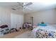 Bright bedroom with a ceiling fan, closet, and a workspace area with a desk at 12918 Hunters Vista Blvd, Orlando, FL 32837