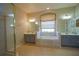 Relaxing primary bath with a soaking tub, separate vanities, and lots of natural light at 1332 Hunterman Lane, Winter Garden, FL 34787