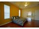 Cozy bedroom with bright yellow walls, wood floors, and connected bathroom at 1332 Hunterman Lane, Winter Garden, FL 34787