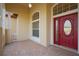 The main entrance has a red, double door with a brick-covered porch and an arched window above at 1332 Hunterman Lane, Winter Garden, FL 34787