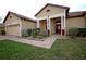 Charming single-story home with a red door, brick walkway, manicured lawn, and two car garage at 1332 Hunterman Lane, Winter Garden, FL 34787