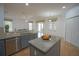 Open kitchen area with granite countertop island, stainless steel appliances, and modern tile flooring at 1332 Hunterman Lane, Winter Garden, FL 34787