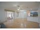Bright living room boasts travertine floors, ceiling fan, and flows to dining area and kitchen at 1332 Hunterman Lane, Winter Garden, FL 34787