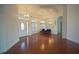 Open-concept living room featuring hardwood floors, high ceilings, and a mirrored wall accent at 1332 Hunterman Lane, Winter Garden, FL 34787