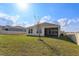 View of the home from the backyard showing lanai and lush green grass at 14436 Topaghan Way, Winter Garden, FL 34787