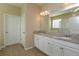 Bathroom with double sinks, granite counters, white cabinets, and a walk-in shower at 14436 Topaghan Way, Winter Garden, FL 34787