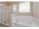 Bright bathroom featuring a separate shower and soaking tub, complemented by a large window at 14436 Topaghan Way, Winter Garden, FL 34787