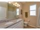 Bright bathroom features double vanity with granite counters, white cabinets, and tub shower at 14436 Topaghan Way, Winter Garden, FL 34787