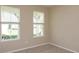 Bedroom with tan walls and carpet and two windows with blinds at 14436 Topaghan Way, Winter Garden, FL 34787