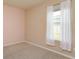 Neutral bedroom featuring tan carpet, light walls, and a window with white curtains at 14436 Topaghan Way, Winter Garden, FL 34787