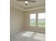 Neutral bedroom with tray ceilings, carpet, and two windows offering views of the backyard at 14436 Topaghan Way, Winter Garden, FL 34787