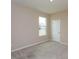 Neutral bedroom with beige carpet and walls, a window, and white trim at 14436 Topaghan Way, Winter Garden, FL 34787