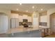 Modern kitchen with a large granite island, white cabinets, stainless steel appliances, and ample lighting at 14436 Topaghan Way, Winter Garden, FL 34787