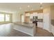 Open kitchen featuring a spacious island with granite countertops, stainless steel appliances, and modern lighting at 14436 Topaghan Way, Winter Garden, FL 34787