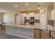 Well-lit kitchen features a granite island, white cabinetry, stainless steel appliances and updated tile backsplash at 14436 Topaghan Way, Winter Garden, FL 34787