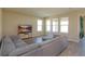 Spacious living room featuring a sectional sofa, large windows, and light wood flooring at 14436 Topaghan Way, Winter Garden, FL 34787