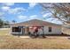 Back exterior of house showing patio, pergola, and red umbrella at 1523 Whooping Dr, Groveland, FL 34736