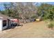 Large backyard with patio furniture under red umbrella and spacious grassy area at 1523 Whooping Dr, Groveland, FL 34736