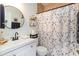 Clean bathroom with white vanity, shower, and geometric patterned shower curtain at 1523 Whooping Dr, Groveland, FL 34736