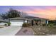 Single-story home with solar panels, attached garage, and landscaped yard at 1523 Whooping Dr, Groveland, FL 34736