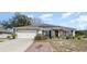 Single-story home with solar panels, attached garage, and neatly trimmed shrubs at 1523 Whooping Dr, Groveland, FL 34736