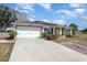 Front view of a house with a two-car garage and a brick walkway at 1523 Whooping Dr, Groveland, FL 34736