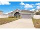 House exterior with gray siding and two car garage at 2011 Begonia Way, Poinciana, FL 34759
