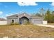 Gray house exterior, two-car garage, and landscaping at 2011 Begonia Way, Poinciana, FL 34759