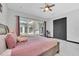 Main bedroom with pool view, ceiling fan, gray wood bed frame, and modern accents at 247 Hampton Loop, Davenport, FL 33837