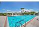 Community pool with crystal clear water, pergola, and lounge chairs at 247 Hampton Loop, Davenport, FL 33837