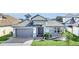 Beautiful single-story home with a gray stone facade, a two-car garage, and manicured landscaping at 247 Hampton Loop, Davenport, FL 33837