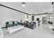 Open-concept living room and kitchen with white cabinets, stainless steel appliances, and modern furnishings at 247 Hampton Loop, Davenport, FL 33837