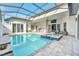 Sparkling pool and spa with screened-in enclosure, patio, outdoor kitchen, and comfortable lounge furniture at 247 Hampton Loop, Davenport, FL 33837