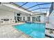 Beautiful backyard featuring a large pool, spa, patio, outdoor kitchen, and comfortable lounge furniture at 247 Hampton Loop, Davenport, FL 33837