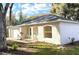 Side view of a charming house with an attached garage, arched entry, and well-maintained landscaping on a sunny day at 333 E Church St, Deland, FL 32724