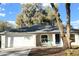 Charming single-story home with a well-manicured lawn, attached garage, and a cozy front porch seating area at 333 E Church St, Deland, FL 32724