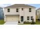 Two-story house with beige siding, two-car garage, and landscaping at 4601 Boxwood Way, Mount Dora, FL 32757