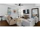 Living room with large TV, comfortable seating, and hardwood floors at 4713 Anson Ln, Orlando, FL 32814