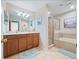 Spacious bathroom with double vanity, walk-in shower, soaking tub, and neutral tile at 5381 Via Appia Way, Sanford, FL 32771