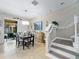 Bright dining area featuring a modern light fixture, sliding glass doors to the patio, and staircase at 5381 Via Appia Way, Sanford, FL 32771